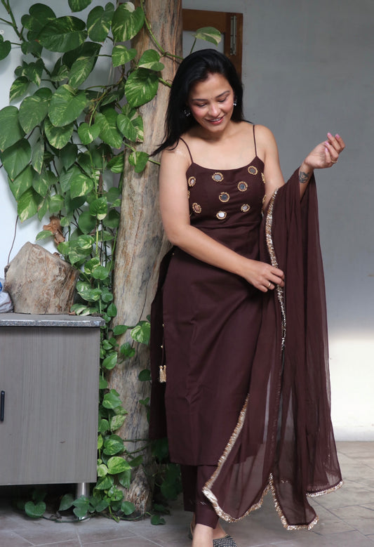 Woman wearing the Shya Brown Cotton Kurta Set in breathable cotton featuring elegant mirror detailing, matching pants, and dupatta by Anaykaa.