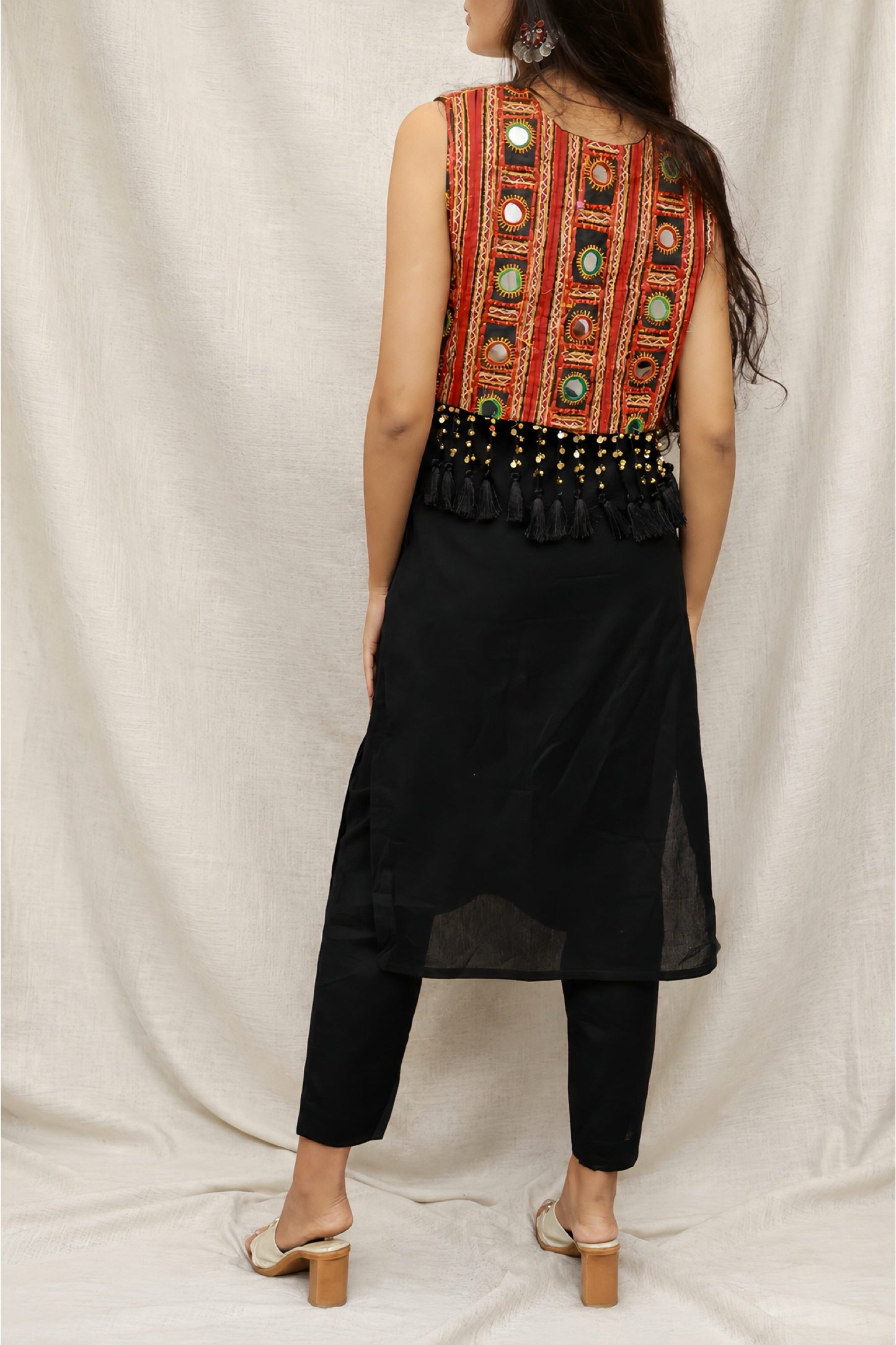 Model wearing the Anaykaa Zariya Kutchi Mirrorwork Jacket Kurta Set in premium black Cotton featuring a handcrafted Kutchi mirrorwork embroidered jacket with tassels and matching straight pants.