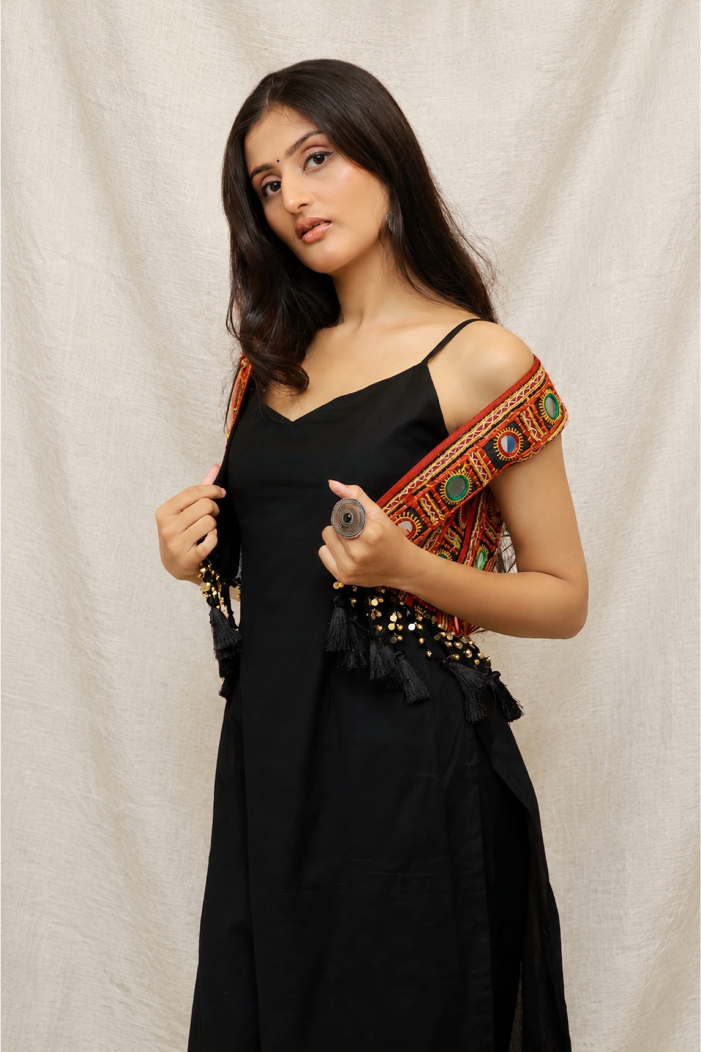 Model wearing the Anaykaa Zariya Kutchi Mirrorwork Jacket Kurta Set in premium black Cotton featuring a handcrafted Kutchi mirrorwork embroidered jacket with tassels and matching straight pants.