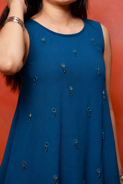 Model wearing the Nysa Teal Mirrorwork Co-ord Set in premium georgette featuring a sleeveless asymmetrical top with mirror work and matching flared pants.