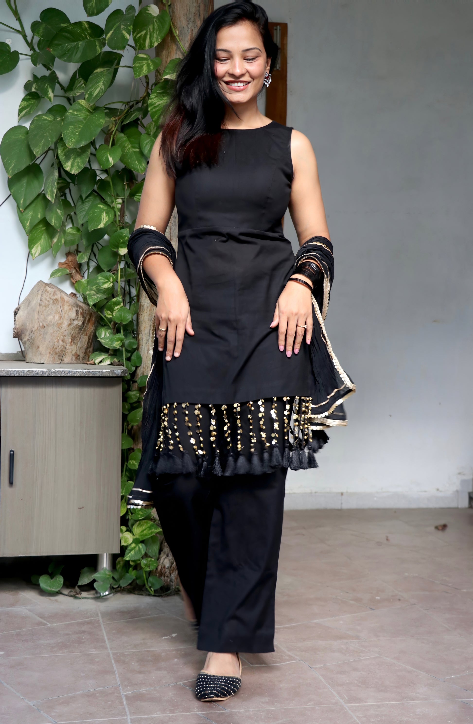 Woman wearing the Tisya Black Suit Set featuring an elegant black kurta, matching bottoms, and coordinated dupatta by Anaykaa.