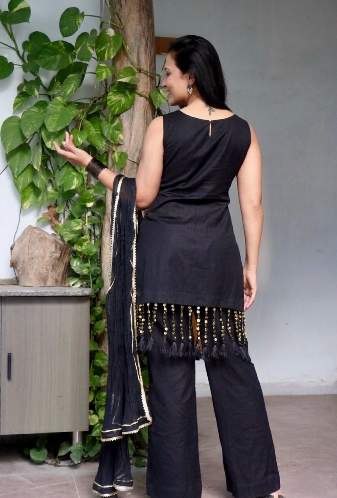 Woman wearing the Tisya Black Suit Set featuring an elegant black kurta, matching bottoms, and coordinated dupatta by Anaykaa.