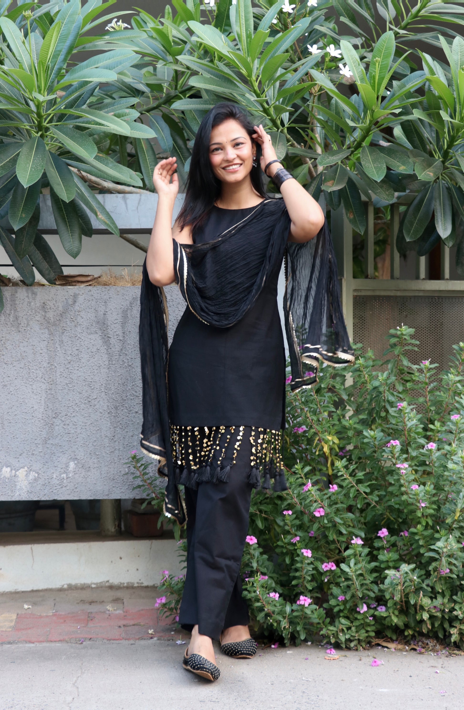 Woman wearing the Tisya Black Suit Set featuring an elegant black kurta, matching bottoms, and coordinated dupatta by Anaykaa.